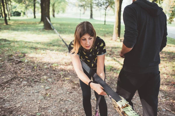 Kobieta Przygotowuje Sprzęt Szkolenia Slacklining Mocowania Szczelina Drzewie Zewnątrz Parku — Zdjęcie stockowe