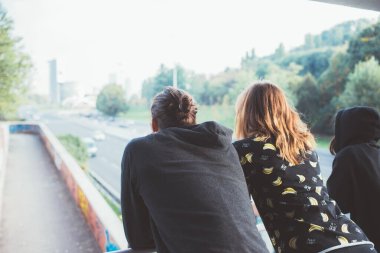 Şehre bakan üç kişi gelecekte hayal kurmayı umut ediyor.