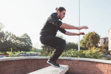 Adrenalinik sportif akrobatik adam parka atlama eğitimi veriyor.