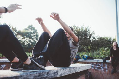 Active athletic sportive friends man woman outdoor training stretching park