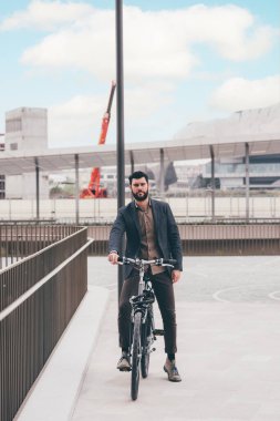 Contemporary bearded young man biking outdoors city commuting the carbon-free way