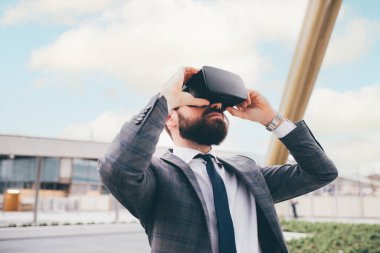 Elegant executive professional businessman bearded using 3D viewer outdoor exploring metaverse cyberspace