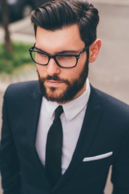 Young elegant professional executive bearded businessman posing outdoors confident and reassuring