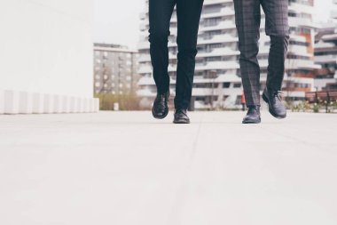 Low section unrecognizable two businessmen walking outdoors. Start, success, ambition concept