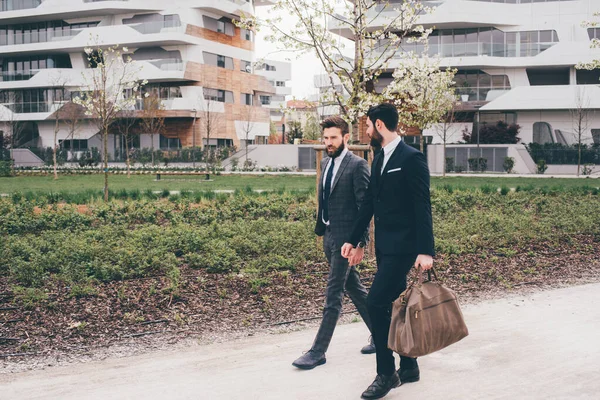 Два Молодых Элегантных Бизнесмена Прогуливаются Улицам Вместе Дизайнерским Строительством Современного — стоковое фото