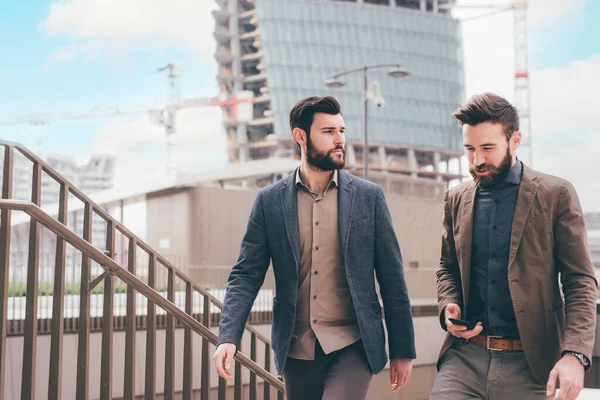 Δύο Νέοι Επιχειρηματίες Εξωτερικούς Χώρους Περπατώντας Σκάλες Μιλώντας Και Κουβεντιάζοντας — Φωτογραφία Αρχείου