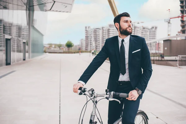 エレガントなひげを生やした若いスタイリッシュなビジネスマンは 自転車で通勤します炭素フリーの方法 — ストック写真