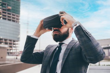 Elegant executive professional businessman bearded using 3D viewer outdoor exploring metaverse cyberspace