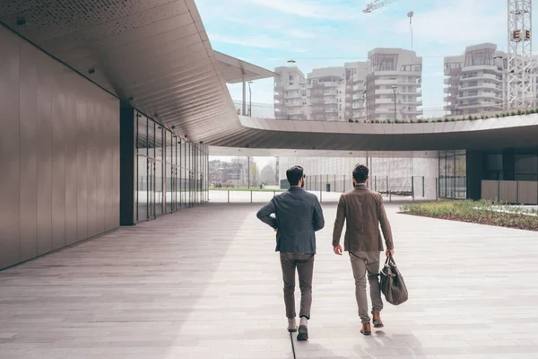 Δύο Νέοι Επιχειρηματίες Εξωτερικούς Χώρους Περπατούν Μιλώντας Και Κουβεντιάζοντας Αφήνοντας — Φωτογραφία Αρχείου