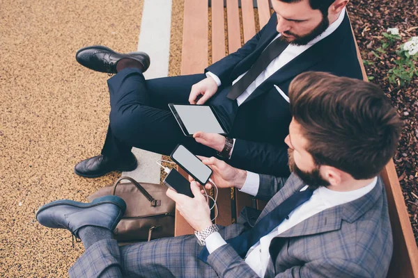 Dwa Eleganckie Biznesmen Siedzi Schody Pomocą Tabletu Smartfona — Zdjęcie stockowe