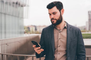 Akıllı telefon kullanan genç bir tasarımcı.