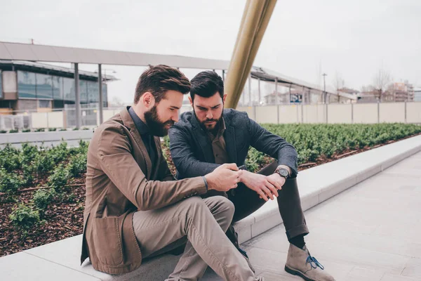 Two Casual Designer Using Tablet Sitting Outdoor Talking Each Other — Stock Photo, Image