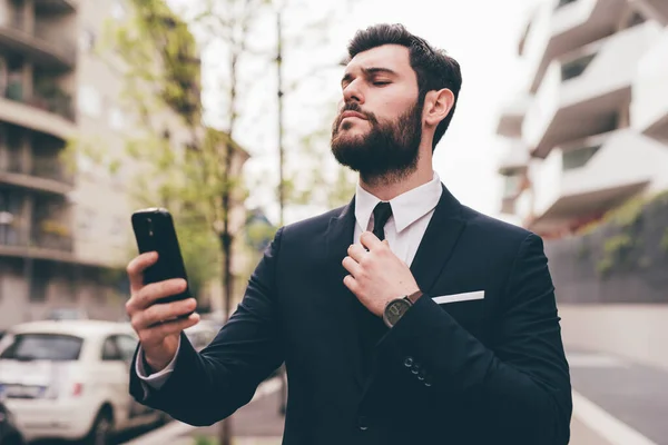 若いひげを生やしたエレガントなビジネスマン屋外でスマートフォンを使用してビデオ通話を行う — ストック写真