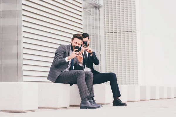 Δύο Νέοι Σύγχρονος Επιχειρηματίας Κάθεται Ένα Παγκάκι Υπαίθρια Στην Πόλη — Φωτογραφία Αρχείου