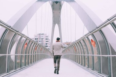 Genç sakallı adam telefonla arkadan konuşuyor.