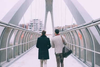 Arkaya bakan iki genç iş adamı dışarıda yürüyor.