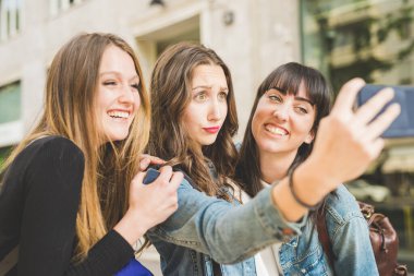 Üç güzel genç kadın selfie çekiyor.