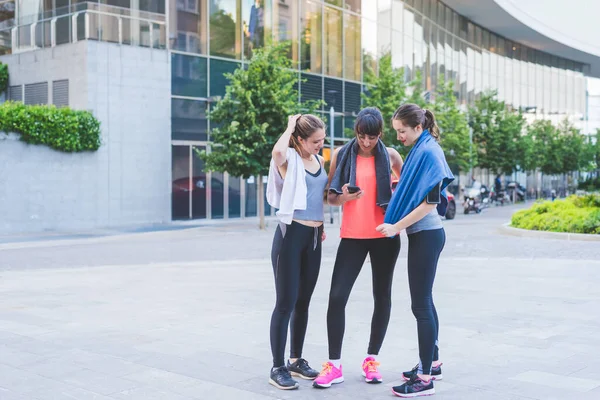 Tři Mladé Sportovní Ženy Mluví Úsměvem Relaxaci Tréninku Pomocí Smartphonu — Stock fotografie
