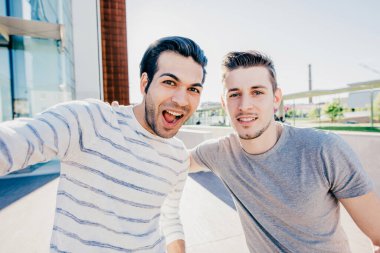 İki çok ırklı arkadaş selfie çekiyor.