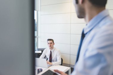 İki milenyum işadamı kapalı bir ofiste buluşuyor.
