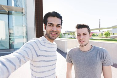 İki çok ırklı arkadaş selfie çekiyor.