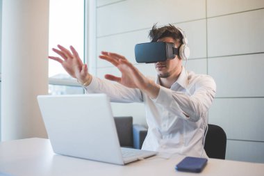 Genç Kafkasyalı işadamı 3D izleyici ve bilgisayar kullanıyor