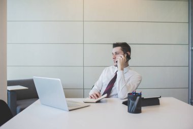 Kafkasyalı genç işadamı akıllı telefonlardan bahsediyor. 