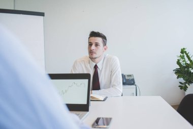 Bilgisayarda birlikte çalışan iki işadamı. 