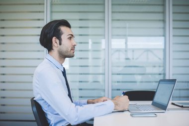 Genç milenyum Hindistanlı işadamı bilgisayar kullanarak çalışıyor. 