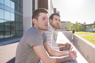 İki farklı etnik çeşitlilikte arkadaş, dışarıda sakin ve kendinden emin poz veriyorlar.