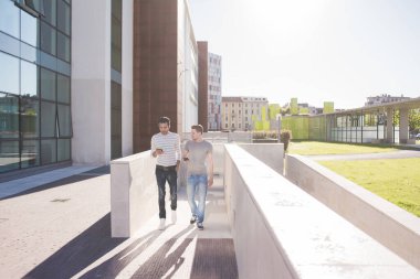 İki çok ırklı arkadaş akıllı telefon kullanıyor. 