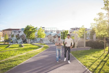 İki çok ırklı arkadaş akıllı telefon kullanıyor. 