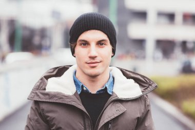 Açık havada gülümseyen genç, güzel bir erkek portresi.