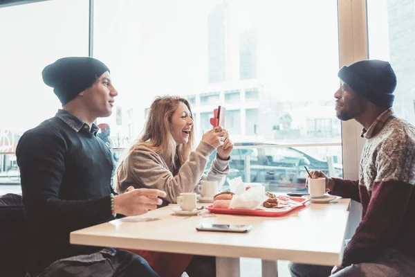 Tre Multietniska Vänner Äter Frukost Med Hjälp Smarttelefon — Stockfoto
