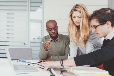 Üç iş arkadaşı içeride etnik çeşitlilikte çalışıyor.