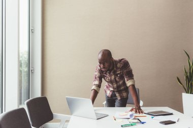 Genç, güzel siyah iş adamı bilgisayar kullanıyor.