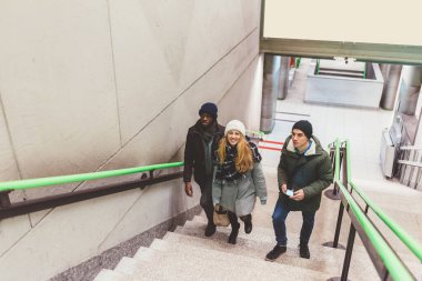 Üç genç yetişkin arkadaş, çok ırklı yürüyen tüp - gezgin, gidip gelen konsept