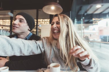 İki arkadaş içeride oturmuş kahvaltı yapıyorlar. Sabah rutini, izin günü, iyi titreşimler konsepti.