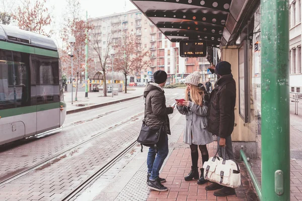 Tre Vänner Väntar Buss Busstationen Utomhus — Stockfoto