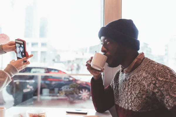 Genç Yetişkin Siyah Bir Adam Kafeteryada Oturmuş Içiyor — Stok fotoğraf