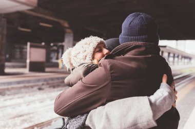 Tren istasyonunda dikilen ve kucaklaşan bir grup çok ırklı arkadaş