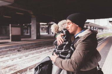 Tren istasyonunda dikilen ve kucaklaşan çift