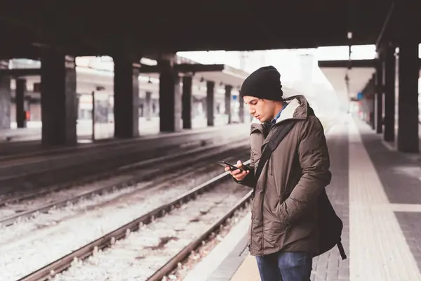 Platformda akıllı telefonla etkileşime geçen beyaz bir adamın portresi