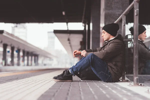 Genç Yetişkin Bir Adam Yerde Oturmuş Tren Istasyonunda Bekliyor — Stok fotoğraf