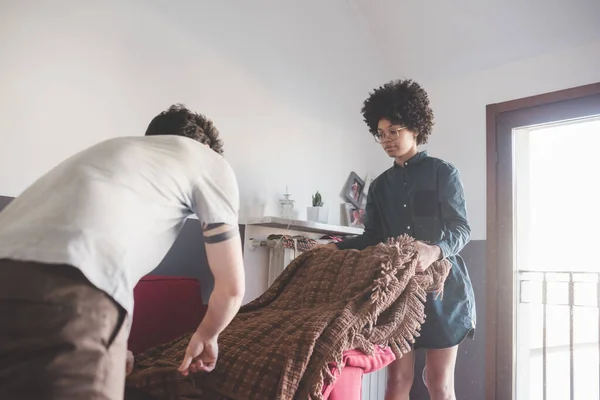 Pasangan Muda Multietnis Dalam Ruangan Rumah Mengatur Seprai — Stok Foto