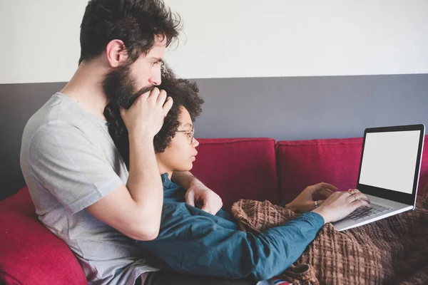 Pasangan Muda Multietnis Dalam Ruangan Menggunakan Komputer Duduk Sofa — Stok Foto