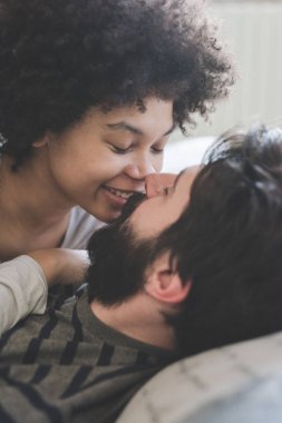 Yatak odasında pijama giyen çok ırklı bir çift.