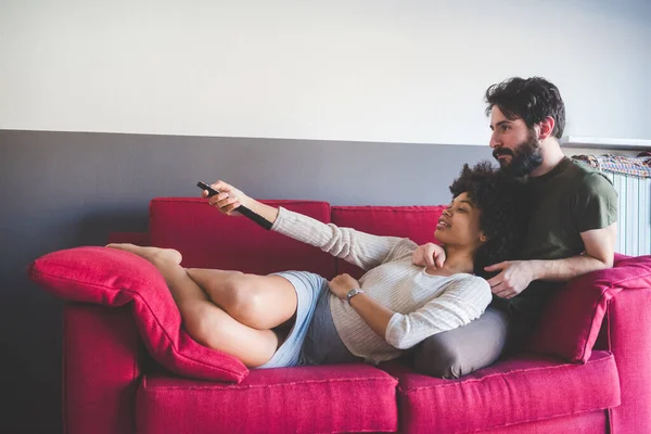 Pasangan Muda Multietnis Dalam Ruangan Duduk Sofa Menonton Televisi — Stok Foto