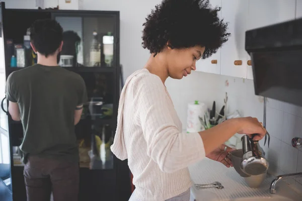 自宅で若いマルチネス女性がガーゼを使用してコーヒーを準備 ストック写真