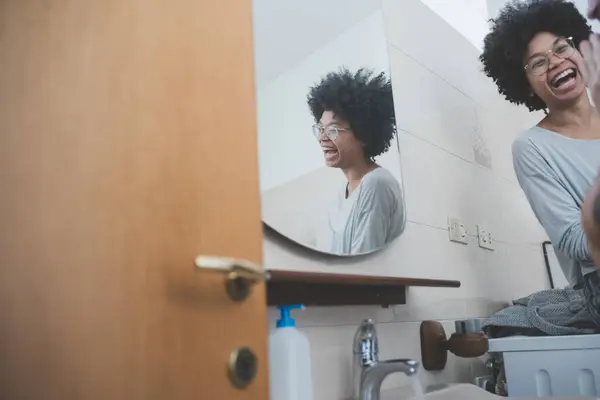 若い多民族ミレニアル世代カップルは一緒にトイレで朝のルーチンを過ごしています ロイヤリティフリーのストック写真